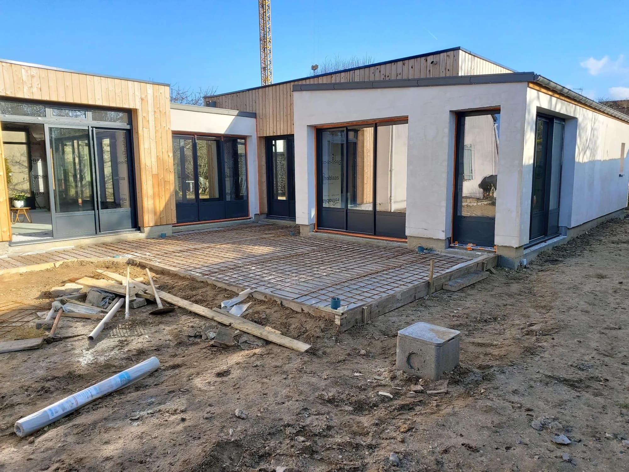 Extension contemporaine en cours de finition avec dalle de terrasse et grandes menuiseries